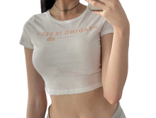 girl wearing cropped tee shirt saying reading is sexy with a peach picture